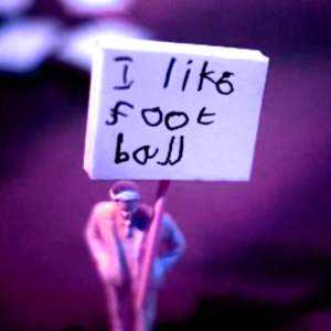 Miniature figurine holding a placard that says, "I like football"