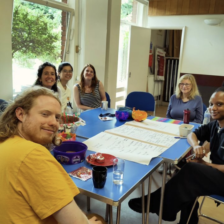 A group of smiling people around a table planning the Make and Chat Mondays Fun Palace.