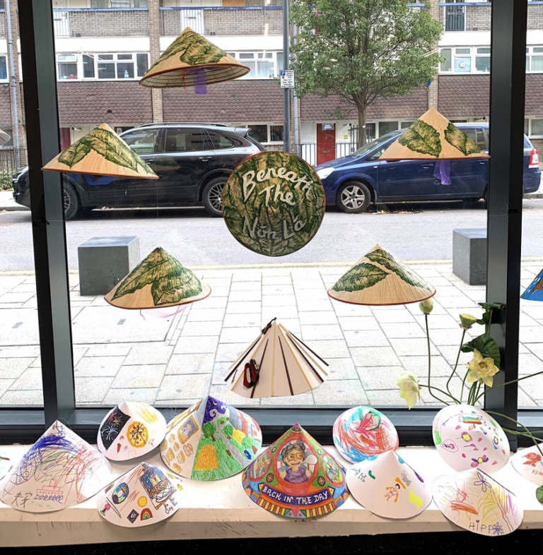 Decorated Vietnamese conical hats (nón lá) displayed in a window - one of the objects in the exhibition.