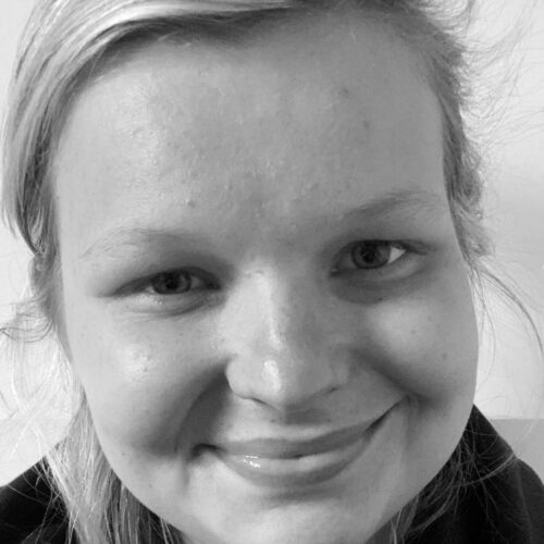 Black and white photo of Beth Sedgwick, a smiling woman with blonde hair.