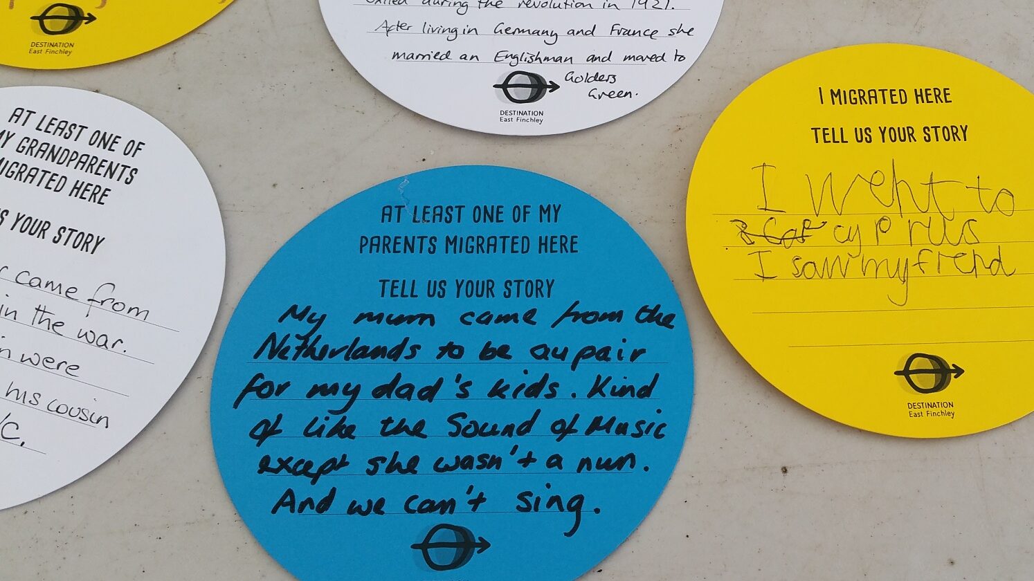Picture of people migration stories written on paper circles. One reads: My mum came from The Netherlands to be an au pair for my dad's kids. Kind of like the Sound of Music except she wasn't a nun. And we can't sing.
