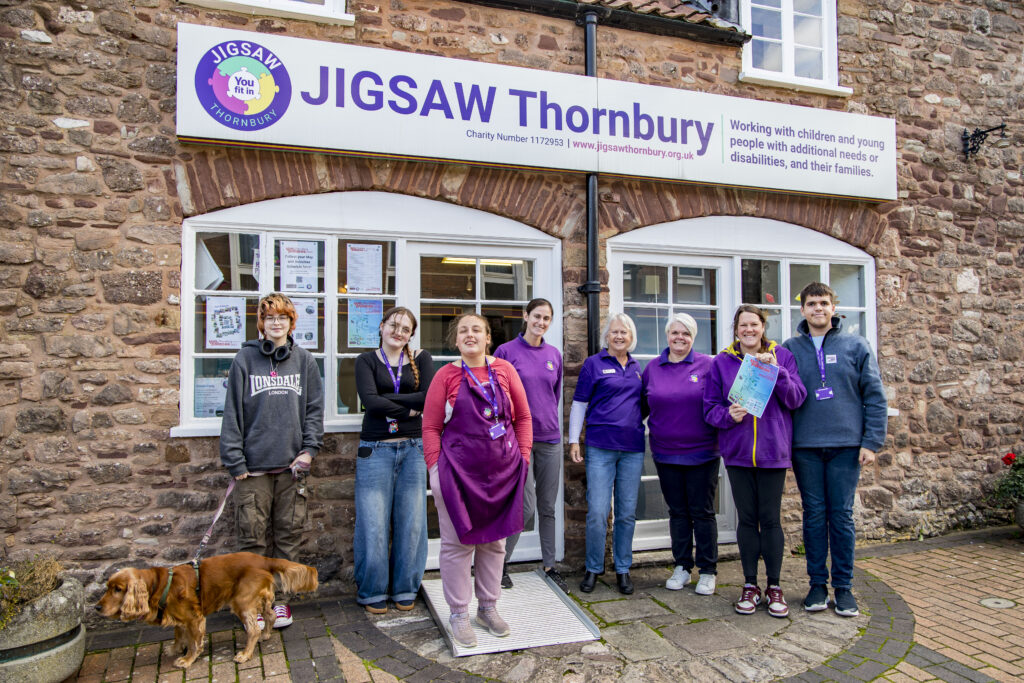 Picture of Jigsaw Thornbury attendees and a dog standing outside Jigsaw Thornbury smiling.