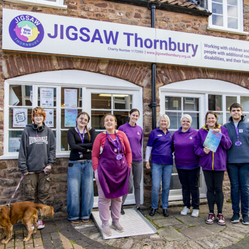 Picture of Jigsaw Thornbury attendees and a dog standing outside Jigsaw Thornbury smiling.