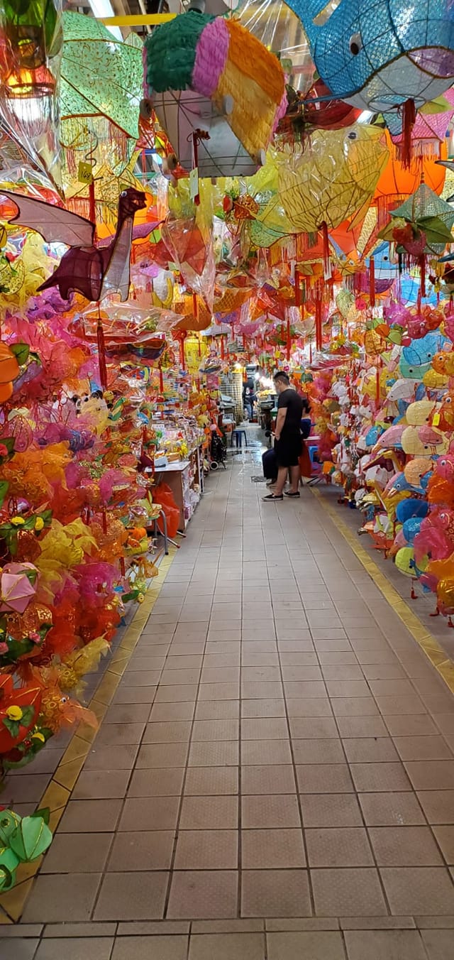 Lanterns of various shapes and sizes hung on the shop fronts in the local market in Hong Kong